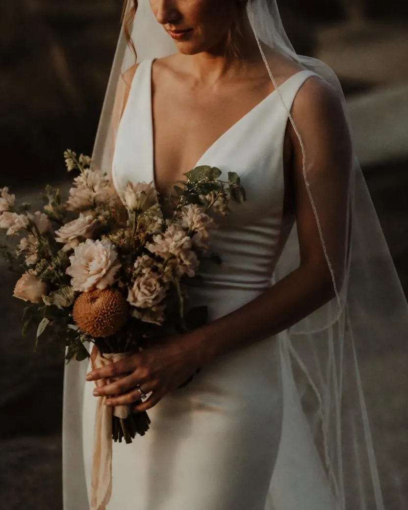 Bride holding her bouquet in warm golden evening light